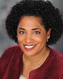 Smiling woman with curly hair, professional portrait.