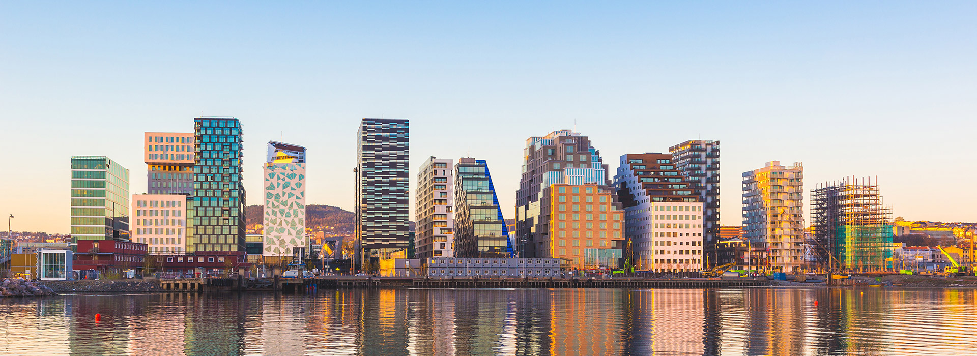 Modern skyline reflecting on calm water.